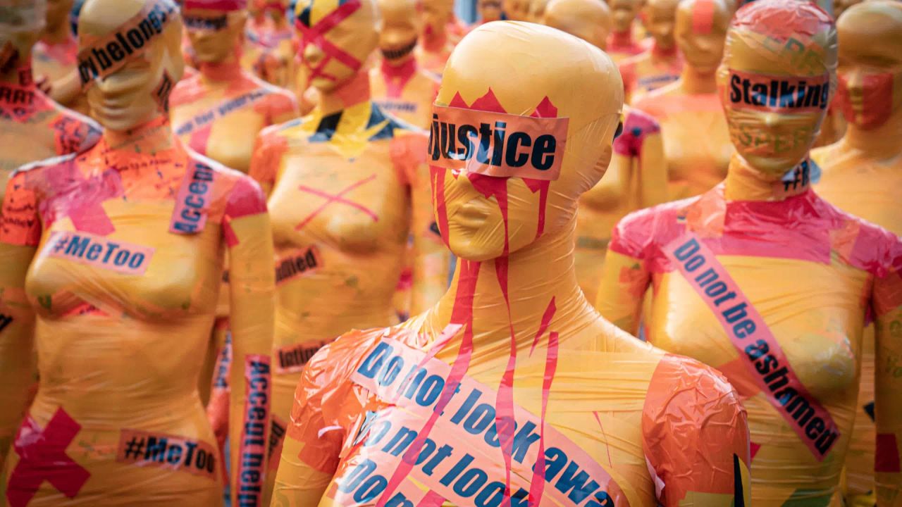 Mannequins wrapped in plastic and tape bearing protest slogans: “Justice”, “Stalking”, “#MeToo”, “Do not look away”.